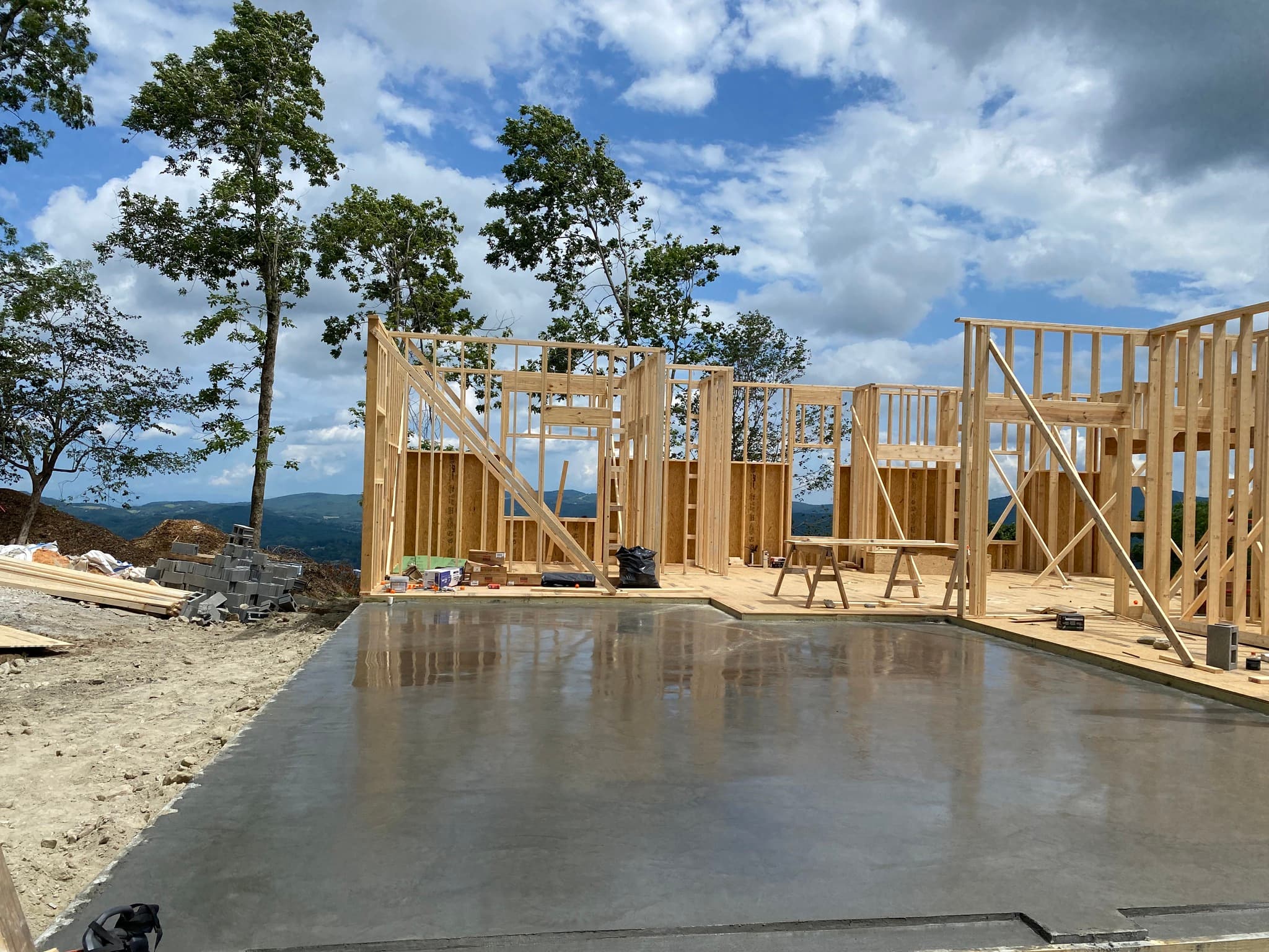 New concrete slab beside mountain views and framed home construction
