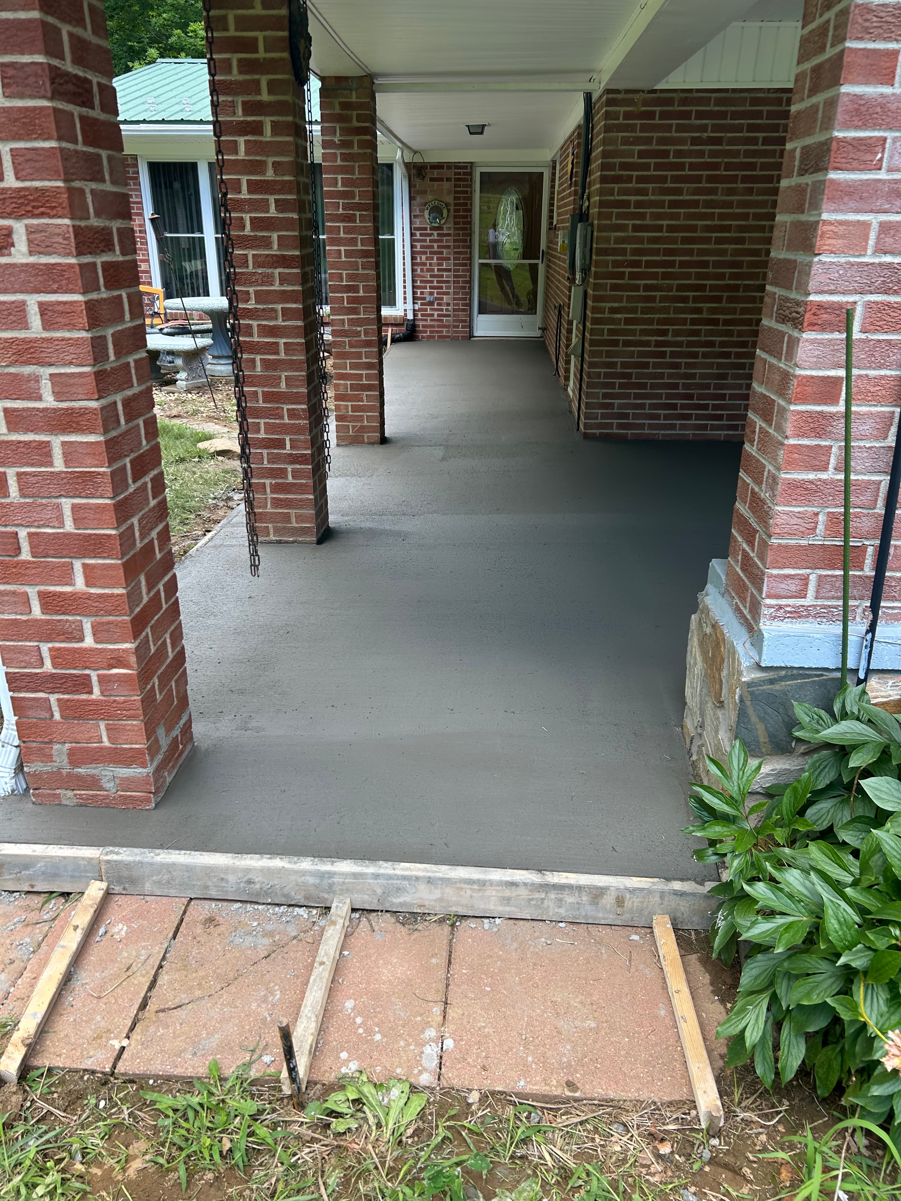 Fresh concrete sidewalk near a brick home